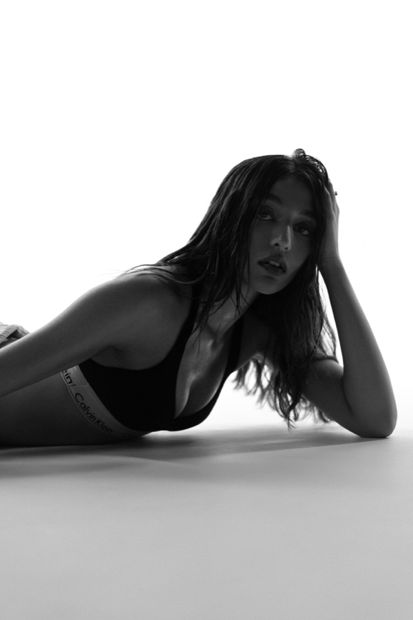 Black and white studio editorial — lying with head resting in hand