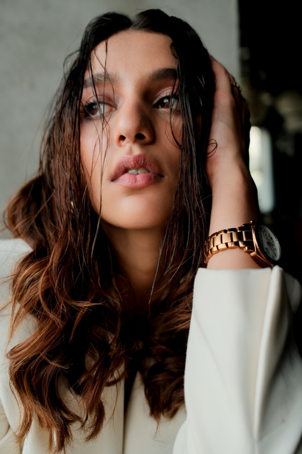 Editorial beauty portrait with wet-look hair and a wristwatch