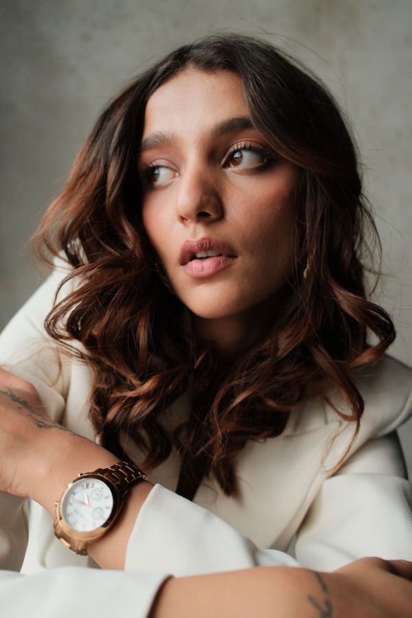 Soft portrait with glossy waves, wearing a cream blazer and gold watch