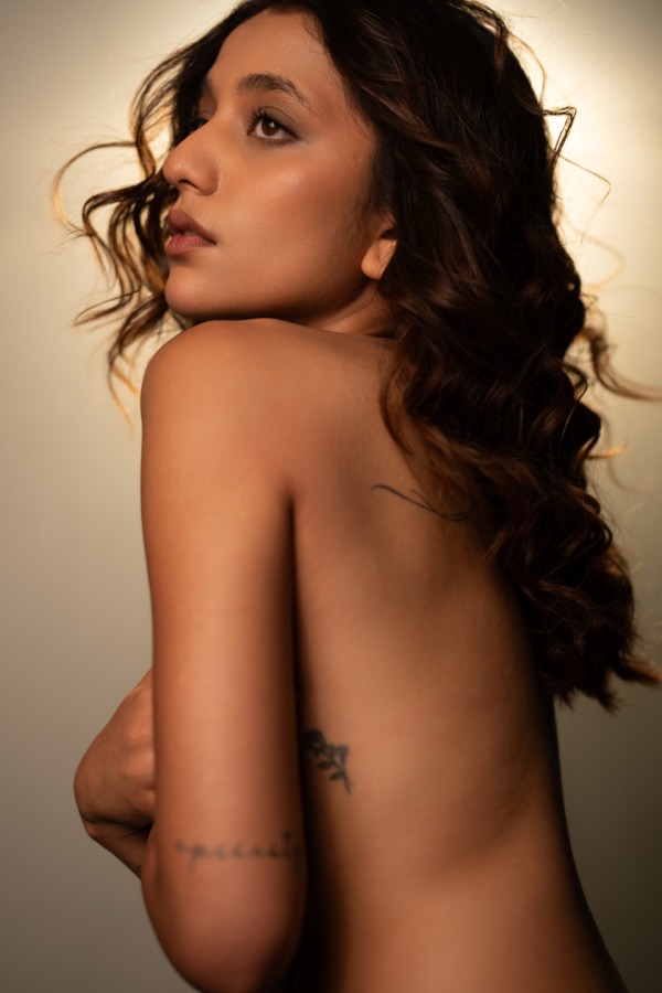 Fine-art back portrait with curled hair, looking over her shoulder