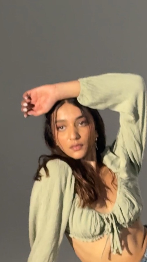 Video still — sage green crop top look in a grey studio